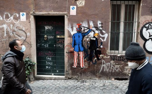На фото: художник Гарри Греб нарисовал в Риме граффити с изображением Дональда Трампа, уходящего после штурма Капитолия в Вашингтоне. (Фото: Fabio Cimaglia/Zuma/TASS)
