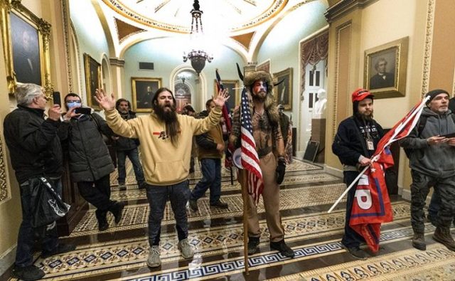 сторонники президента Дональда Трампа противостоят офицерам полиции Капитолия США у здания Сенатской палаты внутри Капитолия в Вашингтоне.