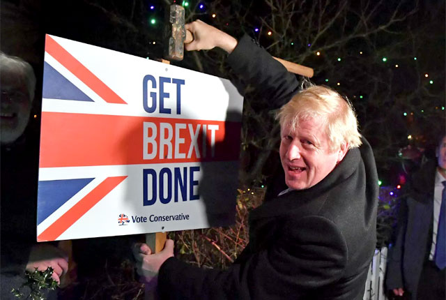 Премьер-министр Великобритании Борис Джонсон с табличкой "Get Brexit Done"