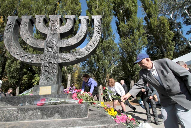 Люди возлагают цветы к памятнику в Национальном историко-мемориальном заповеднике «Бабий Яр»